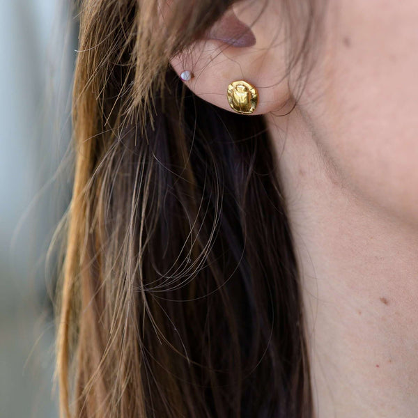 ‘Stackable earrings in recycled silver, gold plated, the messenger collection, beetle design.’