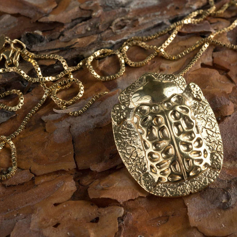‘ close-up of big pendant in recycled gold, the messenger collection, beetle design by Ferunas jewellery.’